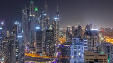 Dubai Marina hava sahasının en yüksek bloğundaki çeşitli gökdelenlerin gece boyunca suni kanalla görüntüsü. Işıkları sönen bir sürü kule