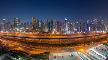 Dubai Marina Gökdelenleri ve Şeyh Zayed Yolu 'nun panorama' sı metro demiryolu ile gece geçişi. Günbatımından sonra modern kulelerin yakınındaki bir otoyolda trafik, Birleşik Arap Emirlikleri