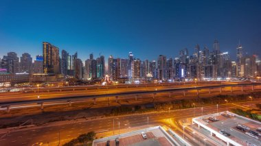 Dubai marinasının panorama 'sı gece gündüz en yüksek gökdelen bloğu. JLT bölgesinden apartman binalarına, otellere ve otoyol yakınlarındaki iş kulelerine hava manzarası.