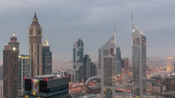 シェイク ザイド ロードとDifcのスカイスクレーパーは アラブ首長国連邦のドバイで夜の遷移に一日 上から金融中心部の空中ビューの塔 日没後の曇天 — ストック写真
