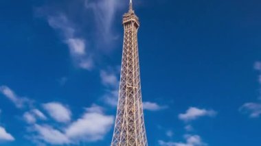Paris 'teki Seine nehrinin rıhtımından Eyfel kulesi zaman atlaması. Güneşli bir yaz gününde, mavi gökyüzünde bulutları olan gemi ve tekneler nehirde.