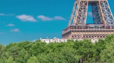 Paris 'teki Seine nehri üzerindeki Bir-Hakeim köprüsünün üzerindeki yeşil ağaçlarla kaplı Eyfel kulesi. Güneşli yaz gününde nehirde gemi ve tekneler