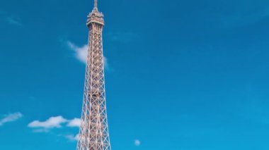 Paris 'teki Seine nehrinin rıhtımından mavi bulutlu arka plan zaman ayarlı Eyfel kulesi. Güneşli yaz gününde nehirde gemi ve tekneler
