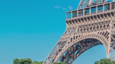 Paris 'teki Seine nehrinin rıhtımındaki ağaçların arkasındaki Eyfel kulesi. Güneşli yaz gününde, Jena Köprüsü 'nün yanındaki nehir kıyısındaki gemi ve tekne istasyonu.