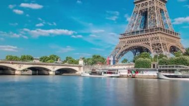 Paris 'teki Seine nehrinin rıhtımından Eyfel Kulesi zaman çizelgesi. Güneşli yaz gününde, Jena Köprüsü 'nün yanındaki nehir kıyısındaki gemi ve tekne istasyonu. Sudaki yansımalar