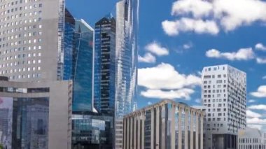 Paris 'te yüksek binaları olan modern iş ve finans bölgelerinin savunma zamanının gökdelenleri. Grande Arche 'dan görüntü. Mavi bulutlu gökyüzü ve modern kulelerde yansımalar.
