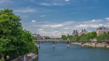 Turistik tekne Pont des Arts 'ın aşağısından geçiyor ve Paris' te Seine Nehri 'nde bir tekne istasyonunda duruyor. Avrupa 'nın en iyi turistik beldesi. Yazın mavi bulutlu gökyüzü