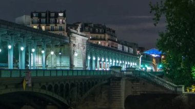 Pont de Bir-Hakeim eski adıyla Pont de Passy gece zaman ayarlı. Seine Nehri 'ni geçen bir köprü. Arabalar ve trenler yolda. Merkezi kemer anıtsal heykellerle süslenmiş. Paris, Fransa