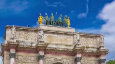 Triumphal Arc de Triomphe du Atlıkarınca zaman atlaması Paris, Fransa 'daki Tuileries bahçelerinde yüksek hızda. Yaz günü mavi bulutlu gökyüzüyle gezen bir turist. En üstteki heykeller