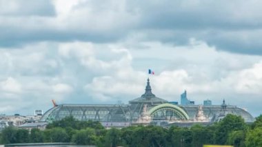 Grand Palais sergi salonu. Bayrak ve botlar Seine Nehri 'nde. Kraliyet Köprüsü' nden görüldüğü gibi. Footbridge Leopold Sedar Senghor. Yaz gününde bulutlu bir gökyüzü