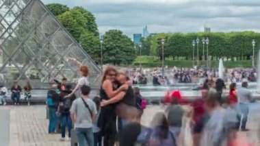 Turistler poz veriyor ve fıskiyelerin yanında fotoğraf çekiyor, ünlü Fransız müzesi. Popüler turistik bir yer. Yaz günü bulutlu bir gökyüzü. Paris, Fransa