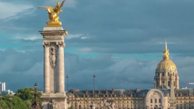 Alexandre III köprüsü Seine nehri boyunca ilerliyor. Süslü Art Nouveau lambaları ve heykellerle süslenmiş. Rıhtımın manzarası. Paris mi? Fransa. Gün batımından önce mavi bulutlu dramatik gökyüzü