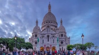 Sacre Coeur Sacred Heart Katedrali 'nin önden görünüşü. Gün batımından sonraki geçiş zamanı. Merdivenlerde oturan insanlar. Paris, Fransa