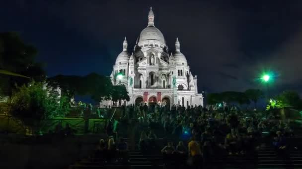 サクレ クールの正面の景色夕暮れ時に照らされる神聖なハート大聖堂は ハイパーラプスを通過します 階段に座っている人が多い フランス — ストック動画