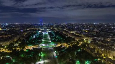 Paris Şehri 'nin ve Mars Sahası' nın Eiffel Kulesi gözlem güvertesinin tepesinde çekilmiş zaman çizelgesi. Akşam aydınlatması yukarıdan