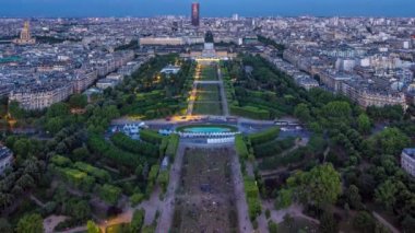 Mars Sahası ile birlikte büyük bir şehrin gökyüzü manzarası ve gün batımından sonra parktan geceye geçiş zamanı. Eyfel Kulesi 'nin gözlem güvertesinin üst görüntüsü. Paris, Fransa.