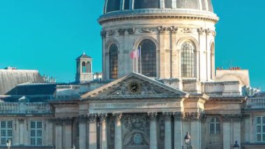 İnsanlar, Fransa Enstitüsü ile Fransa 'nın mavi gökyüzü ile Paris, Fransa arasındaki Seine Nehri üzerindeki Sanat Köprüsü' nde gün batımında müzenin zaman çizelgesi arasında yürürler.