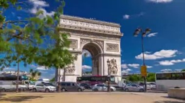 Yıldızların Zafer Takvimi 'nin Zafer Takı. Çevresindeki ağaçlar ve çevre yollarda trafik vardı. Paris 'te Şanzelize' nin batı ucundaki anıt. Mavi bulutlu gökyüzü