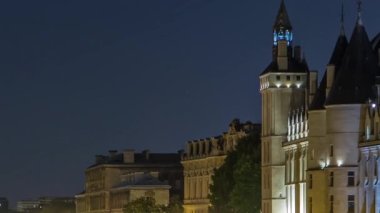 Conciergerie Castle ile Seine nehri üzerindeki kuleleri ve Pont au Change 'i örnek al. Gece aydınlatması suya yansıdı. Fransa, Paris