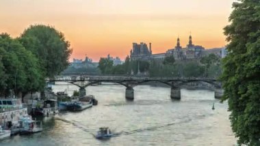 Paris 'te Pont des Arts, gün batımından sonra Pont Neuf, Fransa' dan geçiş zamanı. Seine Nehri 'ndeki gemi Vert-Galant' ın meydanına yakın. Yukarıdan su üzerindeki yansıma ile görüntüle