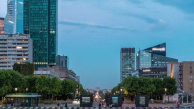 Paris şehir manzarası, modern binalar iş bölgesi La Defense 'da günden geceye geçiş zamanı. Cam cephe gökdelenleri. Arka planda Champs Elysees ile Zafer Takı. Paris, Fransa