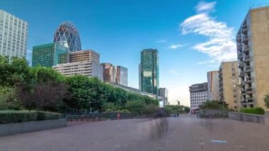 Fransa 'nın başkenti Paris' in banliyölerinde, modern iş ve yerleşim alanlarında La Defansın zaman atlamaları. Yazın mavi bulutlu gökyüzü gün batımını ateşliyor.