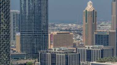Şehir merkezinde metro hattı üstgeçidi ve yolda trafik olan gökdelenler. Sabah gökyüzü manzaralı, kuleli. Dubai, Birleşik Arap Emirlikleri