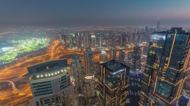Panorama of Dubai Marina with JLT skyscrapers day to night transition , Dubai, United Arab Emirates. Aerial view from above towers after sunset with traffic on highway