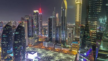 Financial center of Dubai city with luxury skyscrapers day to night transition , Dubai, United Arab Emirates. Aerial view with parking and towers rooftops