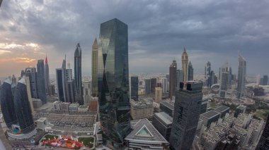 Panorama of futuristic skyscrapers with sunset in financial district business center in Dubai on Sheikh Zayed road . Aerial view from above with orange cloudy sky