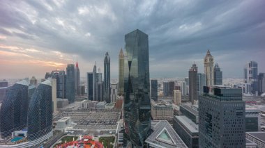 Panorama of futuristic skyscrapers with sunset in financial district business center in Dubai on Sheikh Zayed road . Aerial view from above with colorful cloudy sky