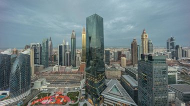 Panorama of futuristic skyscrapers in financial district business center in Dubai on Sheikh Zayed road night. Aerial view from above with illuminated towers with sunrise and long shadows