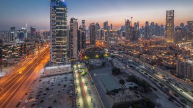 Panoramic view to Dubai's business bay towers aerial day to night transition . Rooftop view of some skyscrapers and new buildings under construction after sunset