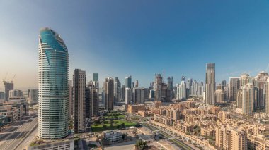 Panorama showing Dubai's business bay and downtown towers aerial morning . Rooftop view of some skyscrapers and new buildings under construction with thaditional houses of old town district