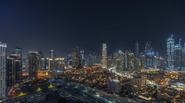 Panorama showing Dubai Downtown and business bay night  with tallest skyscraper and other illuminated towers view from the top in Dubai, United Arab Emirates.