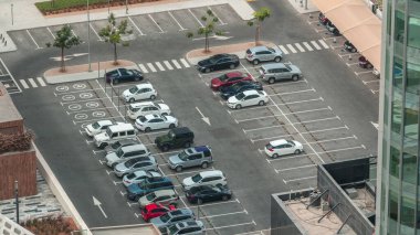 Birçok arabanın sırayla durduğu bir otoparkın havadan görüntüsü. Çalışma saatlerinde ofis binalarının yakınında yer doldurma