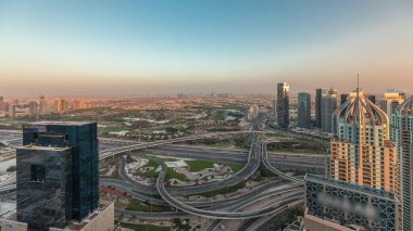 Panorama showing Dubai marina and JLT skyscrapers along Sheikh Zayed Road with huge junction near golf course and media city district aerial . Residential and office buildings from above.