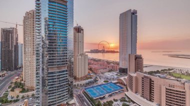 Panoramic sunset view of the Dubai Marina and JBR area and the famous Ferris Wheel aerial  and golden sand beaches in the Persian Gulf