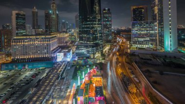 Panorama showing Dubai International Financial district night . Aerial view of business office towers. Illuminated skyscrapers with hotels and shopping malls near downtown