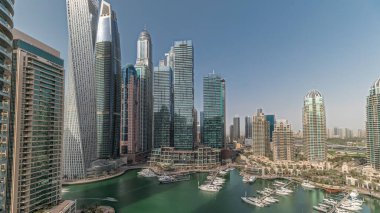 Panorama showing Dubai marina tallest skyscrapers and yachts in harbor aerial . View at apartment buildings, hotels and office blocks, modern residential development of UAE