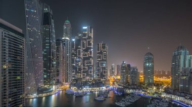 Dubai marinasının en yüksek gökdelenleri ve liman havalimanındaki yatlar tüm gece boyunca ışıklar kapalıyken. Apartman binalarına, otellere ve ofis bloklarına, BAE 'nin modern yerleşim alanlarına bak