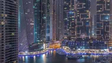 Dubai Marina 'nın lüks turistik bölgesi gökdelenleri ve kuleleri tüm gece kapalı tutuyor. Parlayan pencereleri ve ışıkları sönen gizli binalar.