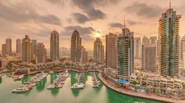 Dubai Marina 'da gündoğumu, gökdelenleri ve kanalın çevresindeki panoramik kuleleri olan lüks turizm bölgesi. Residential binalar ve caddelerdeki trafik