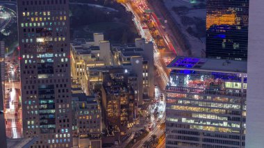Office skyscrapers in financial district aerial day to night transition . Top view to hotels and traffic on a road from above after sunset