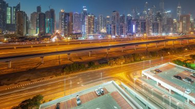 Dubai marinası gece gündüz en uzun gökdelen bloğu. JLT bölgesinden apartman binalarına, otellere ve otoyol ve metro hattı yakınlarındaki iş kulelerine hava panoramik görüntüsü.