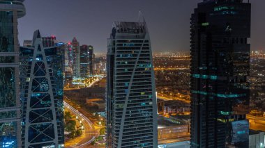 Tüm gece boyunca JLT hava sahasında bulunan yüksek konut binaları Dubai çok amaçlı emtia merkezinin bir parçası. Arka planda villalar ve yol trafiği