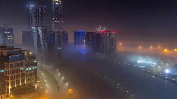Gebäude Sind Der Nacht Eine Dicke Nebelschicht Gehüllt Beleuchtete Wolkenkratzer — Stockfoto