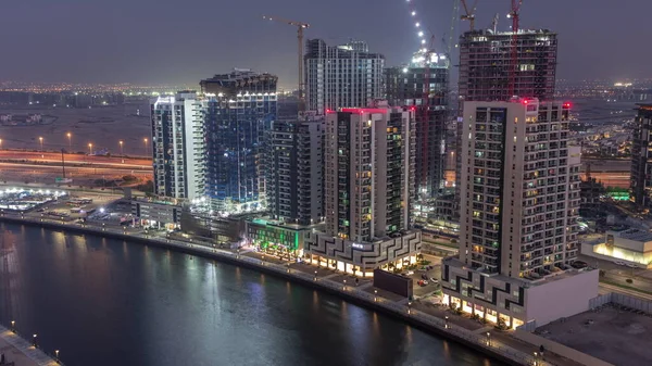 アラブ首長国連邦ドバイのビジネスベイ航空昼から夜への移行でタワー 運河上からの工事現場図 — ストック写真