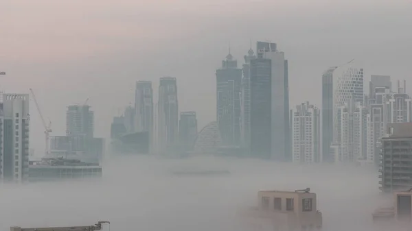 ビジネスベイ地区の夜から昼への移行で朝の霧とドバイの高層ビル アラブ首長国連邦のダウンタウンの上からの空中ビュー — ストック写真