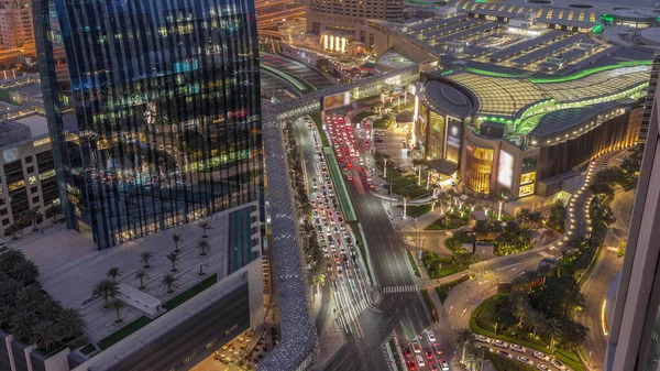 Aerial panorama of Downtown Dubai with shopping mall and traffic on a street day to night transition  from above, UAE Modern skyscrapers and hotels
